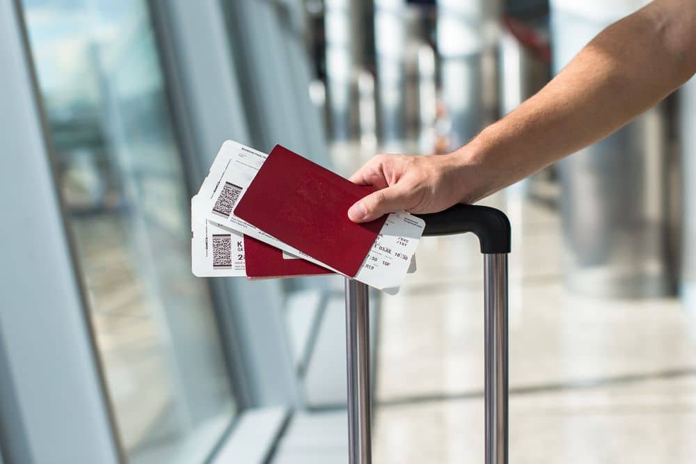 Closeup,Of,Man,Holding,Passports,And,Boarding,Pass,At,Airport Closeup,Of,Man,Holding,Passports,And,Boarding,Pass,At,Airport