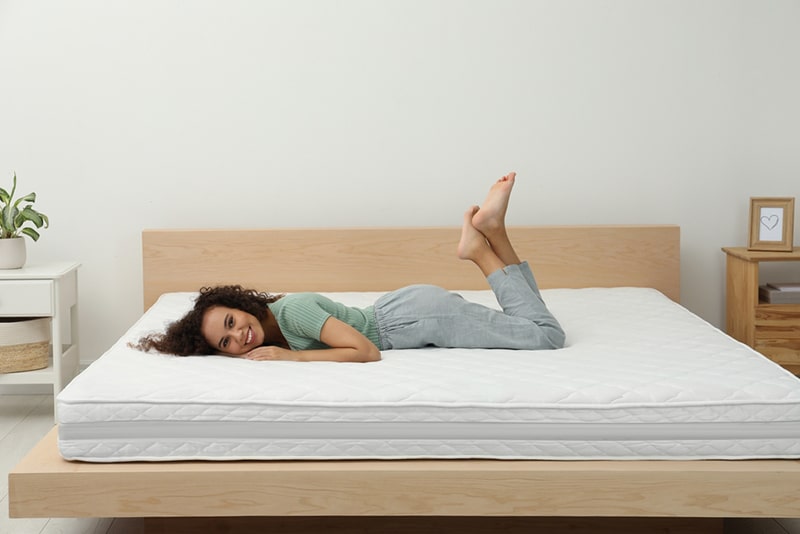 Happy,Young,African,American,Woman,On,Bed,With,Comfortable,Mattress